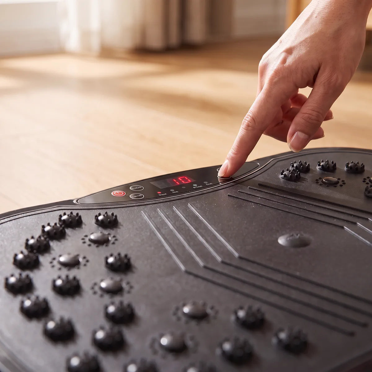 A finger pressing a button on the Drainaea Ripple control panel.