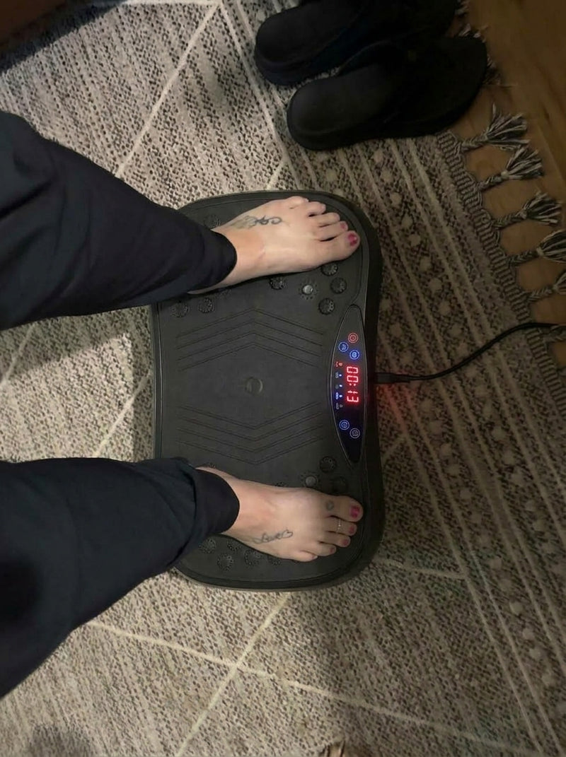 Customer standing barefoot on the vibration plate on a living room rug